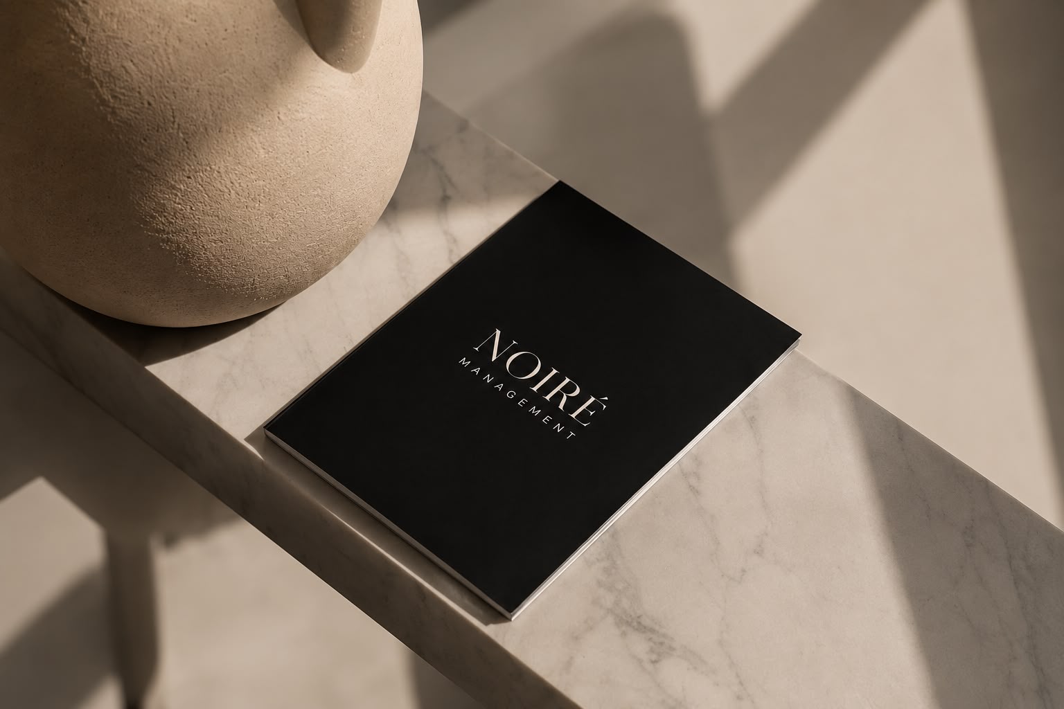 NOIRÉ Management Broschüre auf Marmor